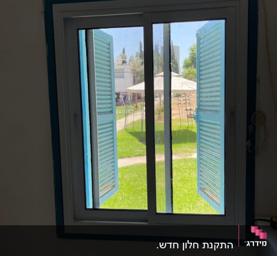 חלון אלומיניום עם תריסים כחולים פתוחים